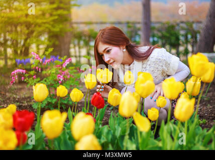 Bella donna con tulipani fiori nel giardino Foto Stock