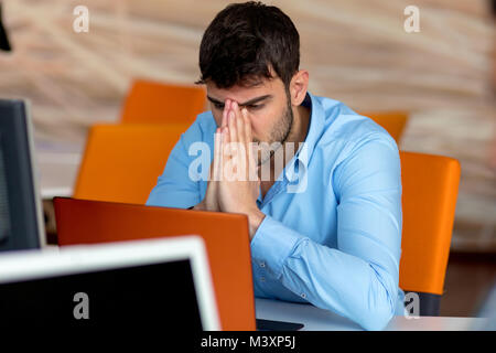 Primo piano della scioccato giovane uomo che lavora sul computer portatile Foto Stock