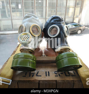 Fabbricato in Ucraina di maschere antigas lieti su una gabbia in legno. Foto Stock