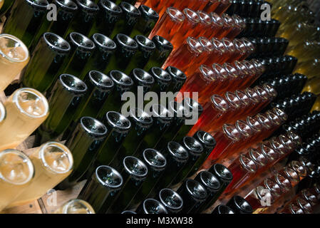 Bottiglie di vino spumante fermentare in cantina Foto Stock