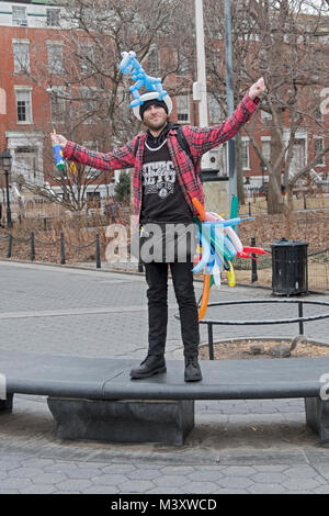 Un giovane uomo che fa animale palloncini sagomati e sollecita contributi in Washington Square Park nel Greenwich Village di New York Cioty. Foto Stock