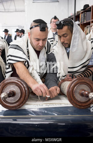 Una religiosa ebraica man (l) è chiamato alla Torah e mostrato dove la Torah e la lettura verrà ripresa. In corrispondenza di una sinagoga nel Queens, a New York Foto Stock