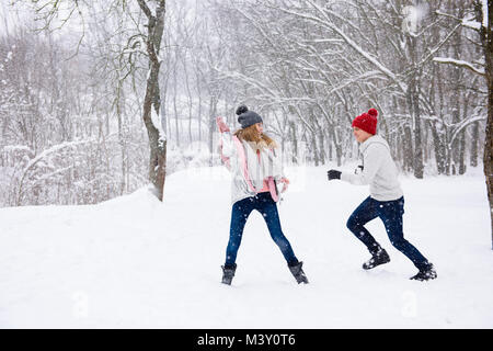 Teenage giovane avendo divertimento nella neve sullo sfondo bianco Foto Stock