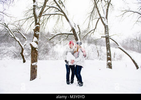 Ragazzo e una ragazza per divertirsi con la neve in inverno forest Foto Stock