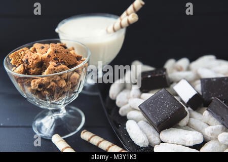 Caramelle, cannucce in crema, biscotti e caramelle sul tavolo Foto Stock