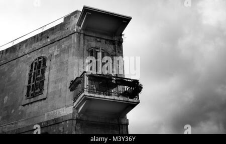 Tavoli e sedie sul balcone con nuvole temporalesche in background Foto Stock