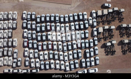 Nuove auto coperto di protezione fogli bianco parcheggiato in una piattaforma di contenimento - riprese aeree Foto Stock