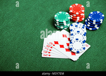 Casino chip e carte su un feltro verde come sfondo Foto Stock