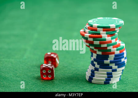 Casino chip e dadi rossi su un feltro verde come sfondo Foto Stock