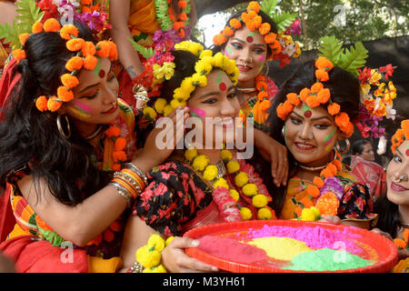 Dacca in Bangladesh. Xiii Febbraio, 2018. Una giovane donna del Bangladesh sorrisi come i suoi due compagni di applicare una polvere colorata sul suo viso durante le celebrazioni del Pahela Falgun festival a Dhaka, nel Bangladesh, Feb 13, 2018. Popolo del Bangladesh Martedì celebrato Pohela Falgun, annunciano l'arrivo della primavera. Credito: Salim Reza/Xinhua/Alamy Live News Foto Stock