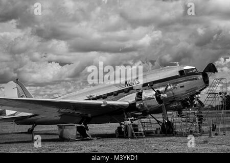 Meccanica colombiano eseguire una routine di pieno controllo di manutenzione di un Douglas DC-3 velivolo al di fuori dell'hangar presso l'aeroporto di Villavicencio, Colombia, 5 dicembre 2016. Sebbene la maggior parte degli aerei della DC-3 serie sono state costruite negli anni quaranta, oggi, quasi 80 anni dopo, alcuni di essi ancora continuare a volare in un servizio giornaliero, attraversando le infinite savane e giungle nel nel sud-est della Colombia. Il trasporto di persone, generi alimentari, bestiame o anche i veicoli di piccole dimensioni, un leggendario aereo americano a volte è la sola connessione tra giungla remoti villaggi e il resto del mondo. Il DC-3 SIF Foto Stock