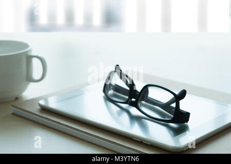 Close up di bicchieri e computer business sul posto di lavoro posto di lavoro in ufficio Foto Stock
