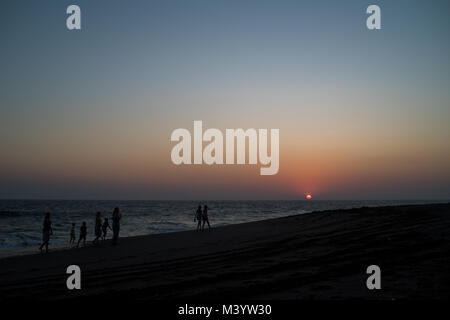 Una famiglia passeggiate lungo la spiaggia al tramonto a Las Penitas, Nicaragua. Foto Stock