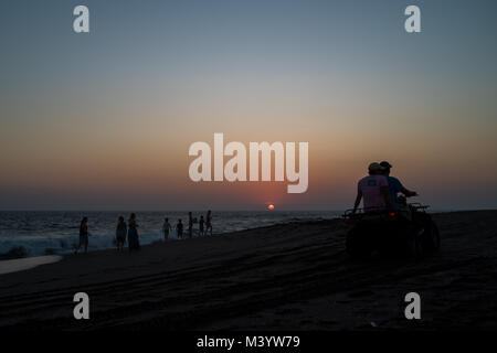 Una unità ATV giù in spiaggia al tramonto a Las Penitas, Nicaragua. Foto Stock