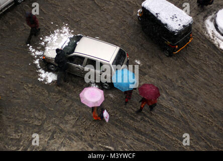 India. 12 Feb, 2018. La gente a piedi sulla strada coperta di neve come nevica a Srinagar la capitale estiva di Indiano Kashmir controllato il 12 febbraio 2018. La nevicata inizia in molte parti del Kashmir costringendo le autorità governative per chiudere Jammu e Kashmir National Highway per veicolare del movimento, il traffico aereo è anche stata interrotta. Credito: Faisal Khan/Pacific Press/Alamy Live News Foto Stock