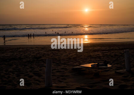 Surfers prendere l'oceano al tramonto a Las Penitas, Nicaragua. Foto Stock