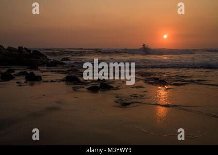 Surfers prendere l'oceano al tramonto a Las Penitas, Nicaragua. Foto Stock