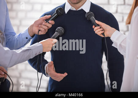 Media conducendo un intervista con la stampa con un imprenditore Foto Stock