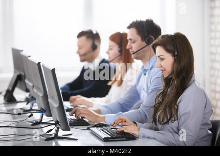 Team di giovani Supporto clienti operatori di telefono lavoro in ufficio Foto Stock