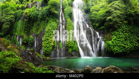 Cascata cascata nascosti nella foresta pluviale tropicale jungle con rock e turchese blue pond. Il suo nome Banyumala perché la sua doppia cascata in montagna Foto Stock