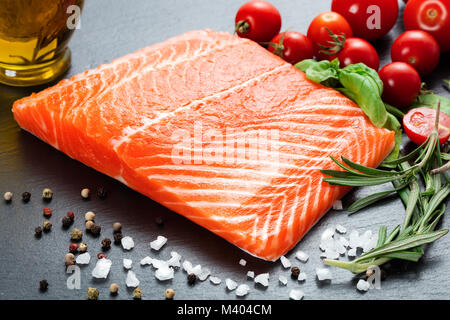Materie filetto di salmone con vari ortaggi su lavagna Foto Stock