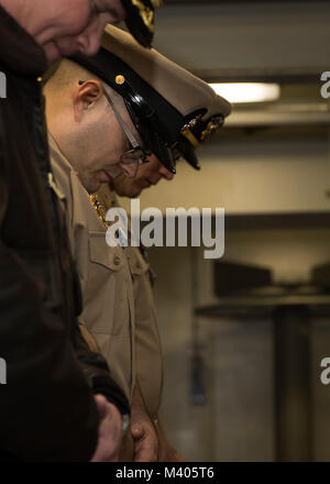 NORFOLK, Virginia (feb. 5, 2018) -- Chief Master-at-Arms Petermartin Noska, assegnato alla USS Gerald Ford (CVN 78) servizio di sicurezza, china il capo per l invocazione durante la sua messa in servizio cerimonia di premiazione che si terrà a la nave il castello di prua. (U.S. Foto di Marina di Massa lo specialista di comunicazione di terza classe Ryan Carter) Foto Stock