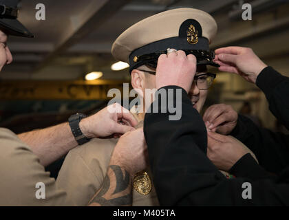 NORFOLK, Virginia (feb. 5, 2018) -- Chief Master-at-Arms Petermartin Noska, assegnato alla USS Gerald Ford (CVN 78) servizio di sicurezza, ha il suo coperchio e chief's ancore rimosso durante la sua messa in servizio cerimonia di premiazione che si terrà a la nave il castello di prua. (U.S. Foto di Marina di Massa lo specialista di comunicazione di terza classe Ryan Carter) Foto Stock