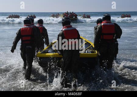 180206-N-UH865-368 CORONADO, California (Feb. 6, 2018) base di demolizione subacquea/tenuta agli studenti di partecipare al passaggio di surf a Naval Amphibious Base Coronado. Passaggio di Surf è uno dei molti fisicamente molto impegnativo evoluzioni che sono una parte della prima fase di formazione della guarnizione. Navy SEALs sono la componente marittima degli Stati Uniti Le forze speciali e sono addestrati per condurre una serie di operazioni dal mare, l aria e la terra. (U.S. Foto di Marina di Massa lo specialista di comunicazione 1a classe Lynn F. Andrews/RILASCIATO) Foto Stock