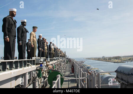 MAYPORT, Fla. (feb. 7, 2018) Marinai e Marines uomo le rotaie sul ponte di volo dell'assalto anfibio nave USS Iwo Jima (LHD 7) come esso si discosta Naval Station Mayport per una distribuzione a sostegno di le operazioni di sicurezza marittima e di teatro di sicurezza gli sforzi di cooperazione in Europa e il Medio Oriente. L'Iwo Jima Amphibious Ready Group si imbarca il ventiseiesimo Marine Expeditionary Unit e include Iwo Jima, il trasporto anfibio dock nave USS New York (LPD 21), il dock landing ship USS Oak Hill (LSD 51), Fleet team chirurgico 8, elicotteri Sea Combat Squadron 28, Tactical Air Control Squadron 22, Foto Stock