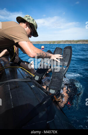 L'eliminazione degli ordigni esplosivi tecnico di terza classe Bryan Rede tende a diver l'eliminazione degli ordigni esplosivi tecnico 1a classe Ruben Villegas durante la miniera di subacquea contromisure formazione in Apra Harbor, Guam, Febbraio 7, 2018. Entrambi sono assegnati per l'eliminazione degli ordigni esplosivi unità mobile 5 (EODMU-5). EODMU-5 contatore conduce operazioni di IED, rende sicuro rischi di esplosione e disarma esplosioni subacquee. EODMU-5 è assegnato al comandante, Task Force 75, il primario expeditionary task force responsabile per la pianificazione e la realizzazione di zone costiere operazioni fluviali, l'eliminazione degli ordigni esplosivi, immersioni subacquee Foto Stock