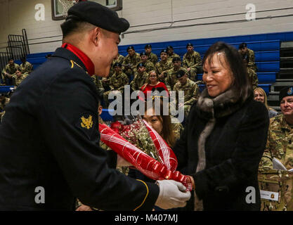 CAMP CASEY, Repubblica di Corea - Kyong Suk Kendall, moglie del comando Sgt. Il Mag. Cesar J. Zertuche, il comando in uscita sergente maggiore del primo battaglione, 38th campo reggimento di artiglieria, 210th campo brigata di artiglieria, seconda divisione di fanteria, ROK-US Divisione combinato riceve un mazzo di rose rosse durante un cambio di responsabilità cerimonia, 8 febbraio Le rose rosse simboleggiano il cuore, la cura e la devozione al Battaglione di acciaio. (U.S. Esercito foto di PFC. Keonhee Lee, 210th FA BDE PAO) Foto Stock