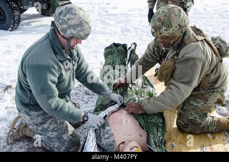 FORT MCCOY, Wis. - STATI UNITI Esercito personale di riserva Sgt. Javar Manley (destra) e SPC. Jonathan Hessel, medici, Task Force Triad, funzionamento freddo acciaio II, coprire un'emergenza simulatore paziente con una coperta di emergenza durante una evacuazione medica prova a Fort McCoy, Wis., Febbraio 8, 2018. Funzionamento a freddo è di acciaio negli Stati Uniti La riserva di esercito di equipaggio è servita la qualifica di armi ed esercizio di convalida per garantire America's Army unità di riserva e soldati sono addestrati e pronti per il deployment su breve preavviso come parte della forza di pronto X e portare la lotta contro-ready e letale di armi da fuoco a sostegno dell'esercito e il nostro comune partner Foto Stock