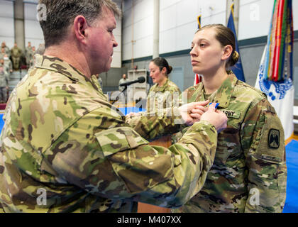 Stati Uniti Esercito Alaska comandante generale, il Mag. Gen. Mark O'Neil perni del soldato sulla medaglia Spc. Rosalind Stromberg durante una cerimonia a Fort Wainwright, Alaska, 8 febbraio 2018. Spc. Stromberg ha ricevuto il premio per il salvataggio di un uomo di vita dopo una valanga mortale vicino a delta giunzione, Alaska il 3 aprile 2016. Dopo il trattamento la vittima per lo shock e prevenire l'ipotermia rimase con lui per cinque ore, a temperature di congelamento fino a quando i servizi di emergenza sono arrivati. (U.S. Foto dell'esercito da Staff Sgt. Sean Brady) Foto Stock