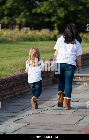 Due sorelle tenendo le mani e camminare insieme Foto Stock