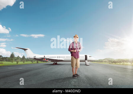 Bello viaggiatori asiatici con zaino pronto alla partenza in aereo sullo sfondo Foto Stock