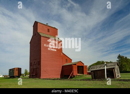 Scandia, Alberta, Canada. Elevatore granella contro uno sfondo di cirrus nuvole nel cielo blu all'EID Parco Storico in tarda estate. Foto Stock