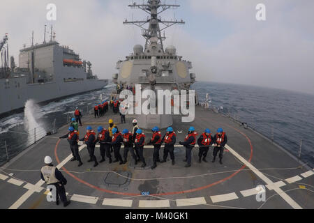 170328-N-ZE250-474 OCEANO ATLANTICO (28 marzo 2017) velisti assegnati al Arleigh Burke-class guidato-missile destroyer USS Carney (DDG 64) tenere il telefono e la linea a distanza durante un rifornimento in mare con la forza militare di comando Sealift carichi secchi e munizioni nave USNS Robert E. Perry (T-AKE 5). Carney è distribuita a Rota, Spagna, conducendo la sua pattuglia di terzi negli Stati Uniti Sesta flotta area di operazioni a sostegno degli Stati Uniti per gli interessi di sicurezza nazionali in Europa. (U.S. Foto di Marina di Massa lo specialista di comunicazione di terza classe Weston Jones/RILASCIATO) 170328-N-ZE250-474 dal curatore di fotografia Foto Stock