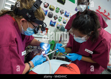150412-N-NK HATTIEVILLE134-168, Belize, (12 aprile 2015) - Da sinistra, Dott Jan Westberry, un dentista e volontario con l'Università della California di San Diego Pre-Dental società (UCSD PDS) e Selina Mahesri, un odontotecnico e volontario con UCSD PDS, pulire a denti del paziente al governo Hattieville Scuola, uno dei due siti medici istituito per militari di comando Sealift USNS Comfort (T-AH 20) al personale medico di fornire servizi durante la continua promessa 2015. Continuando la promessa è un U.S. Comando sud-sponsorizzato e U.S. Forze Navali Comando meridionale/STATI UNITI 4a flotta-condotta deploymen Foto Stock
