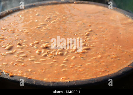 Close-up di fatti in casa i fagioli cotti al forno in ceramica pentola sul tavolo Foto Stock