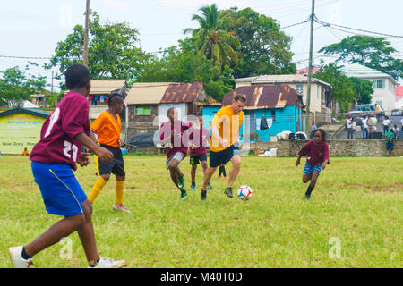 150730-N-YM856-221 ROSEAU, Dominica (30 luglio 2015) della Cmdr. Bradley Killenbeck, nativo di Spencer corte, N.Y., assegnato a al Centro Medico Navale di Portsmouth Virginia, gioca a calcio con bambini dominicani durante una comunità i rapporti eventi a supporto di continuare promessa 2015. Continuando la promessa è un U.S. Comando sud-sponsorizzato e U.S. Forze Navali Comando meridionale/STATI UNITI 4a flotta-condotto di distribuzione condotta civile-militare comprendente le operazioni di aiuto umanitario assistenza civile, esperto in materia di scambi, medico, dentista, veterinario e il supporto tecnico e la risposta di emergenza a partner n Foto Stock