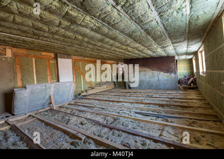 Soffitta della casa in costruzione. Mansarda pareti e soffitto con isolamento in lana di roccia. Isolamento in fibra di vetro materiale in cornice di legno per barriera fredda. Foto Stock