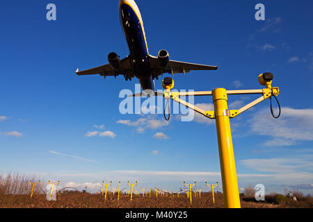 Un passeggero Ryanair jet volando sopra la pista approccio sistema di illuminazione prima dello sbarco. Foto Stock