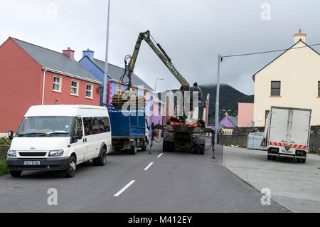 Strada bloccata come un camion lo scarico di pali recinzione su un piccolo camioncino in Allihies sulla penisola di Beara. L'Irlanda meridionale. Foto Stock