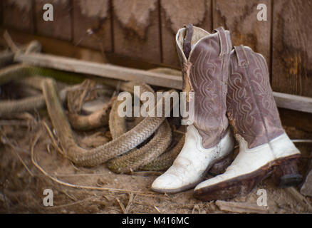 Un vecchio paio di scartato western stivali da cowboy, che si trova nel retro di un fienile, tiro con un 3¼ poll f/2,75 B&L lente di Petzval Foto Stock