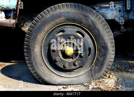 Molto vecchio pneumatico sgonfio parcheggio auto Foto Stock