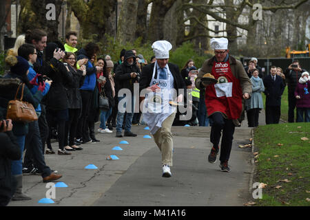 Matt Warman MP (sinistra) e BBC News correspondent James Landale prendendo parte al Pancake parlamentare gara in aiuto dei Rehab disabilità la carità, a torre di Victoria Gardens di Westminster a Londra. Foto Stock