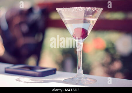 Martini ciliegie cocktail drink e vetro sul tavolo Foto Stock