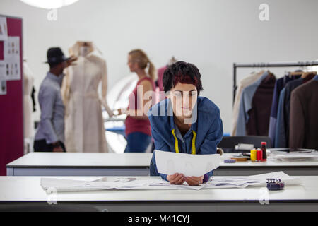 Fashion designer che lavora per la raccolta in studio di occupato Foto Stock