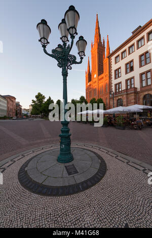 Una vecchia strada lampada che adorna la piazza del Castello e la facciata di Marktkirche illuminata dal sole al tramonto. Wiesbaden, Germania Foto Stock