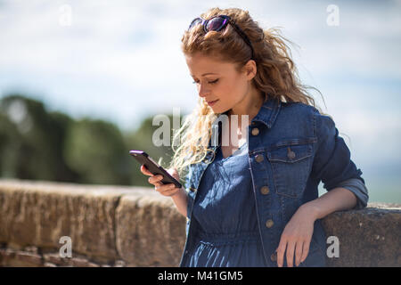 Giovane femmina adulta utilizza lo smartphone Foto Stock